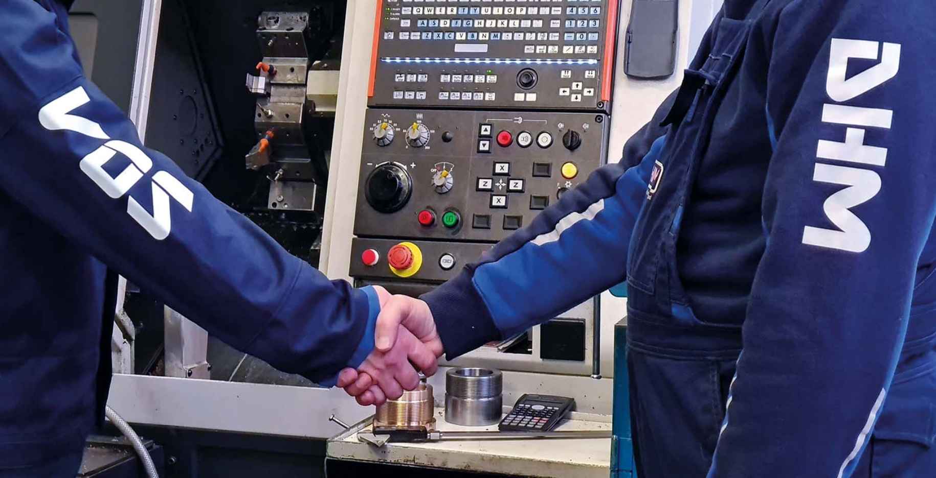 Two people in a Vos and DHM outfit shaking hands